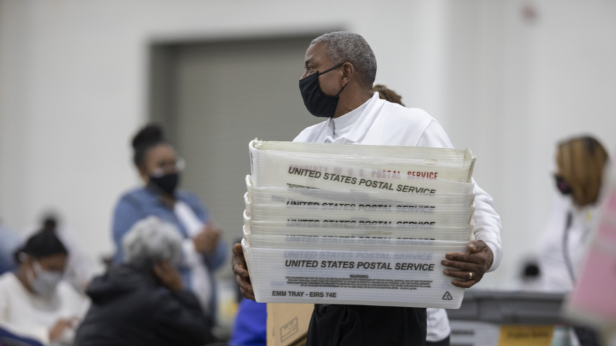 A worker with the Detroit Department of Elections carries empty boxes used to organize absentee ballots after nearing the end of the absentee ballot count at the Central Counting Board in the TCF Center in Detroit, Mich. on Nov. 4, 2020. (Elaine Cromie/Getty Images)